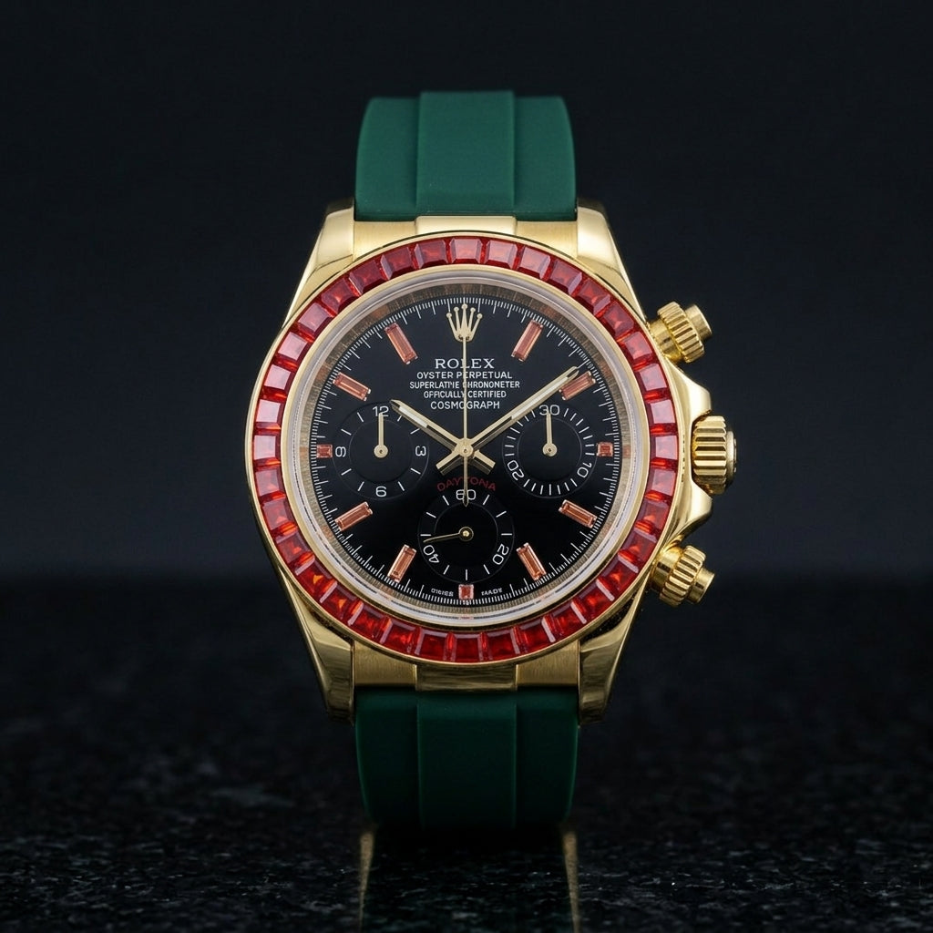 Gold chronograph with a red stone bezel and a black dial on a dark green rubber strap, upright on polished black granite