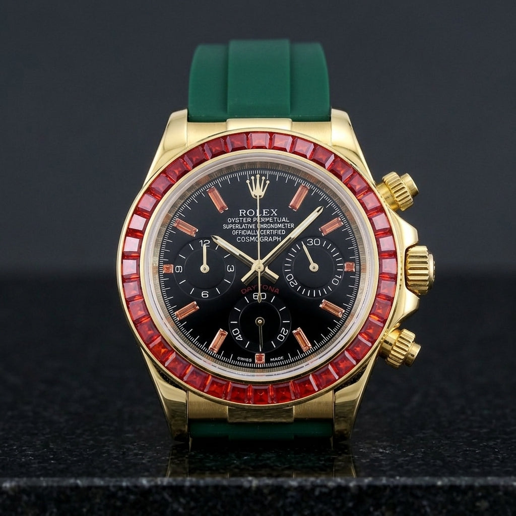 Gold chronograph with a red stone bezel on its dark green rubber strap, worn on the wrist below a dark suit cuff