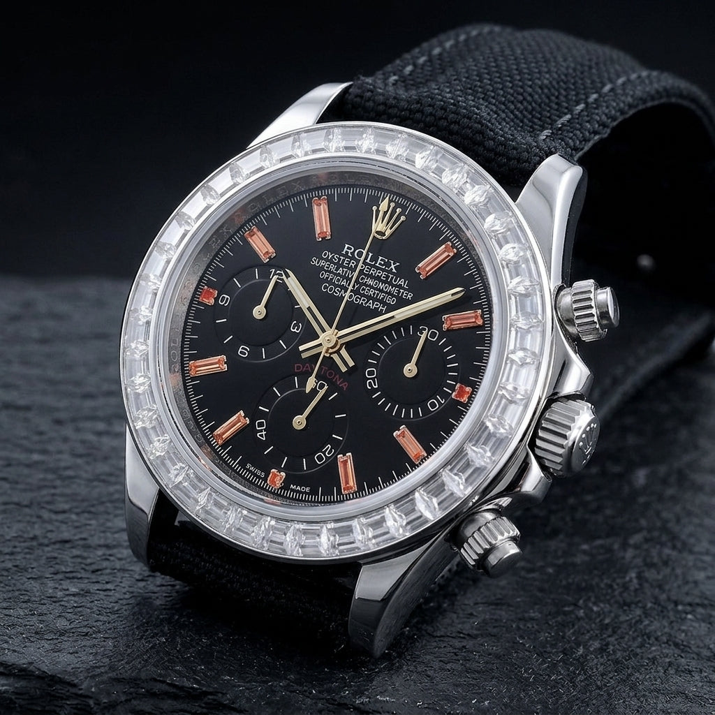 Steel chronograph at a three-quarter angle on dark slate, the clear bezel stones beside the fluted steel crown and pushers
