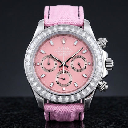 Steel chronograph with a pink dial and a bezel of clear baguette-cut stones, upright on polished black granite