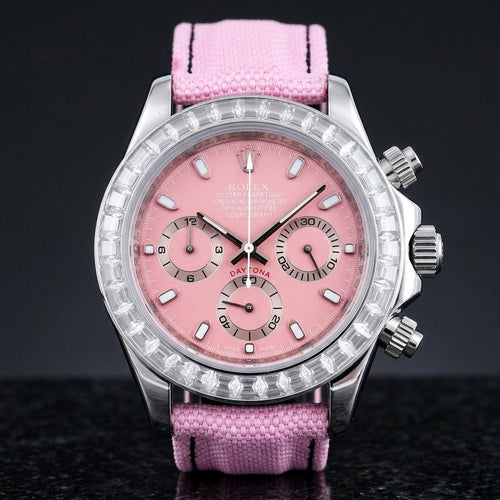 Steel chronograph with a pink dial and a bezel of clear baguette-cut stones, upright on polished black granite