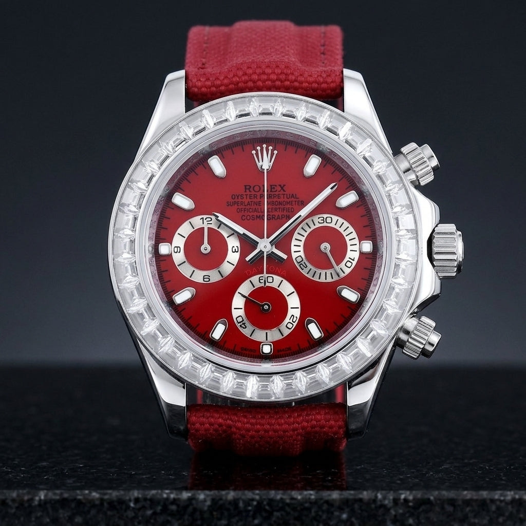 Steel chronograph with a cherry-red dial and a bezel of clear baguette-cut stones, upright on polished black granite