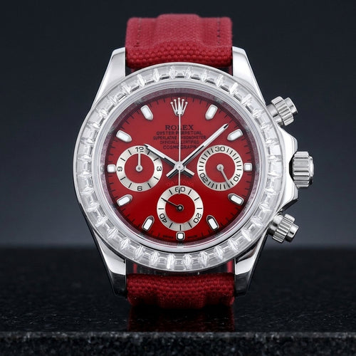 Steel chronograph with a cherry-red dial and a bezel of clear baguette-cut stones, upright on polished black granite