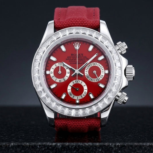Steel chronograph with a cherry-red dial and a bezel of clear baguette-cut stones, upright on polished black granite