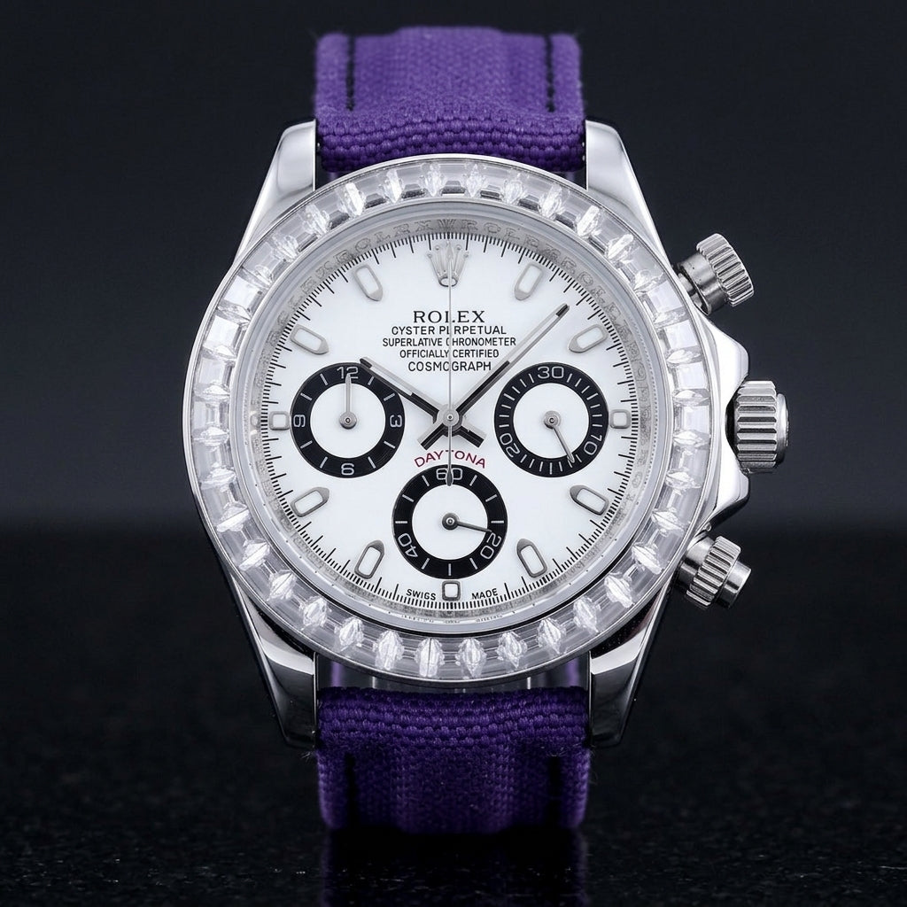 Steel chronograph with a white dial, three black-ringed counters and a bezel of clear baguette-cut stones, upright on polished black granite