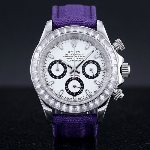 Steel chronograph with a white dial, three black-ringed counters and a bezel of clear baguette-cut stones, upright on polished black granite