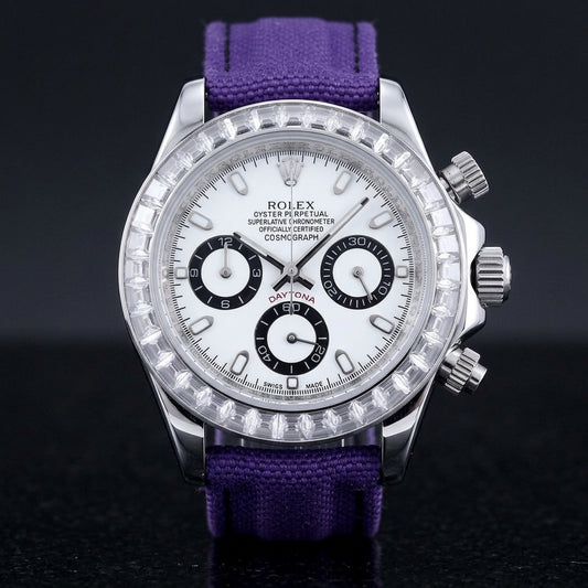 Steel chronograph with a white dial, three black-ringed counters and a bezel of clear baguette-cut stones, upright on polished black granite
