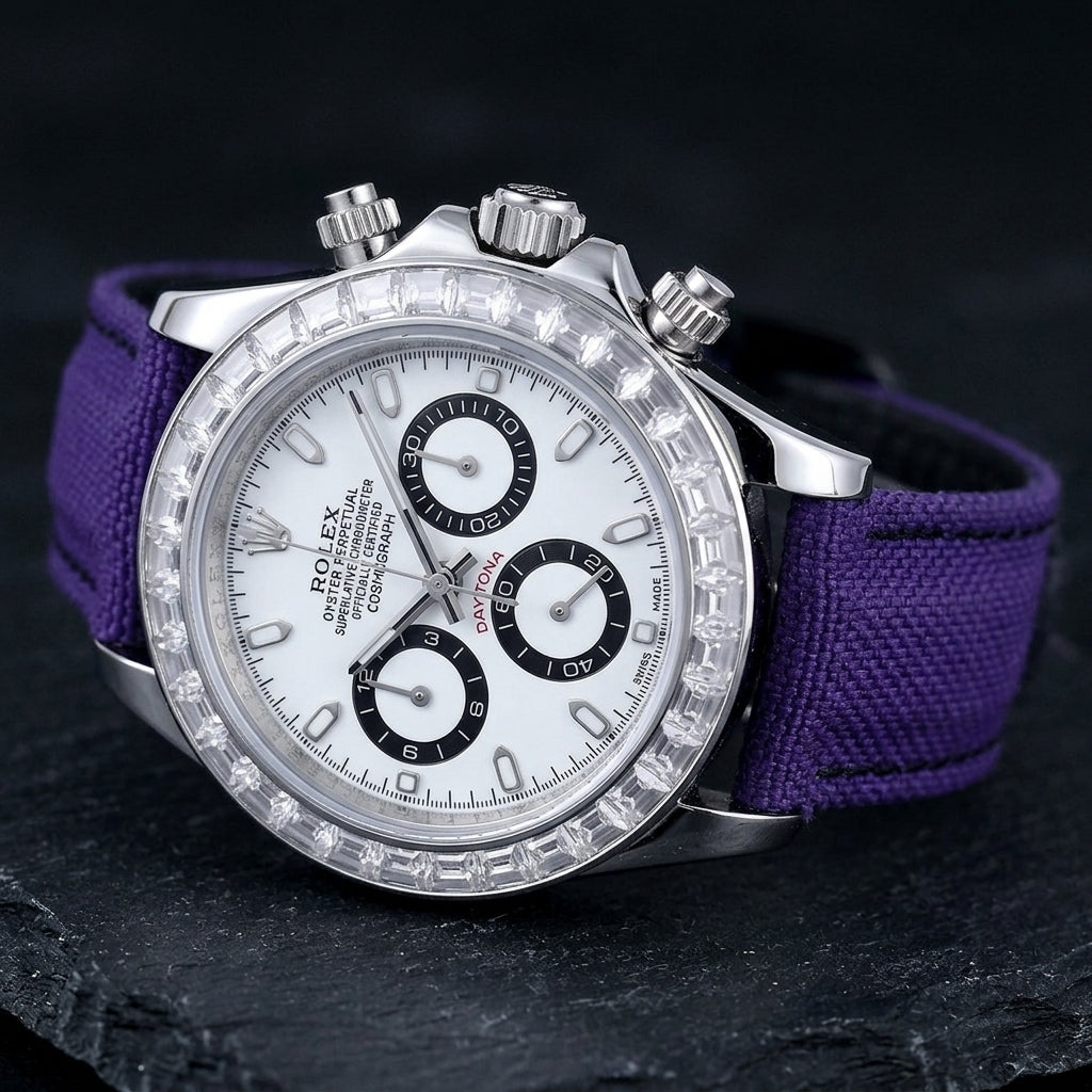 Steel chronograph at a three-quarter angle on dark slate, the clear stone bezel above the fluted steel crown and pushers