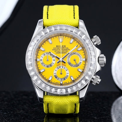 Steel chronograph with a yellow dial on its lemon-yellow canvas strap, worn on the wrist below a dark suit cuff