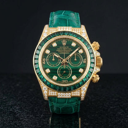 Gold chronograph with a green stone dial and emerald bezel on black granite