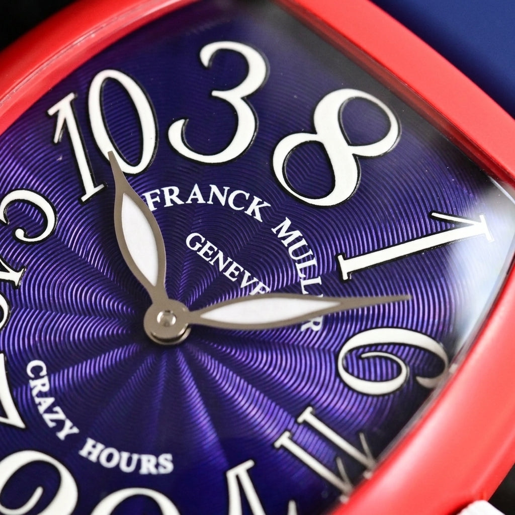 Macro of the deep blue guilloché dial with large white numerals set out of order and polished-steel leaf hands