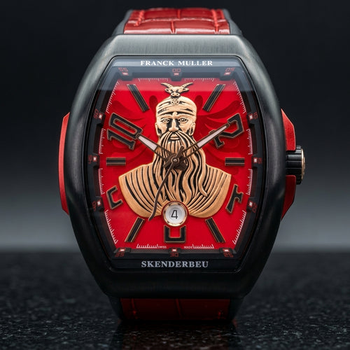 Black curved tonneau watch with a red dial and a raised gold-tone warrior bust, upright on polished black granite