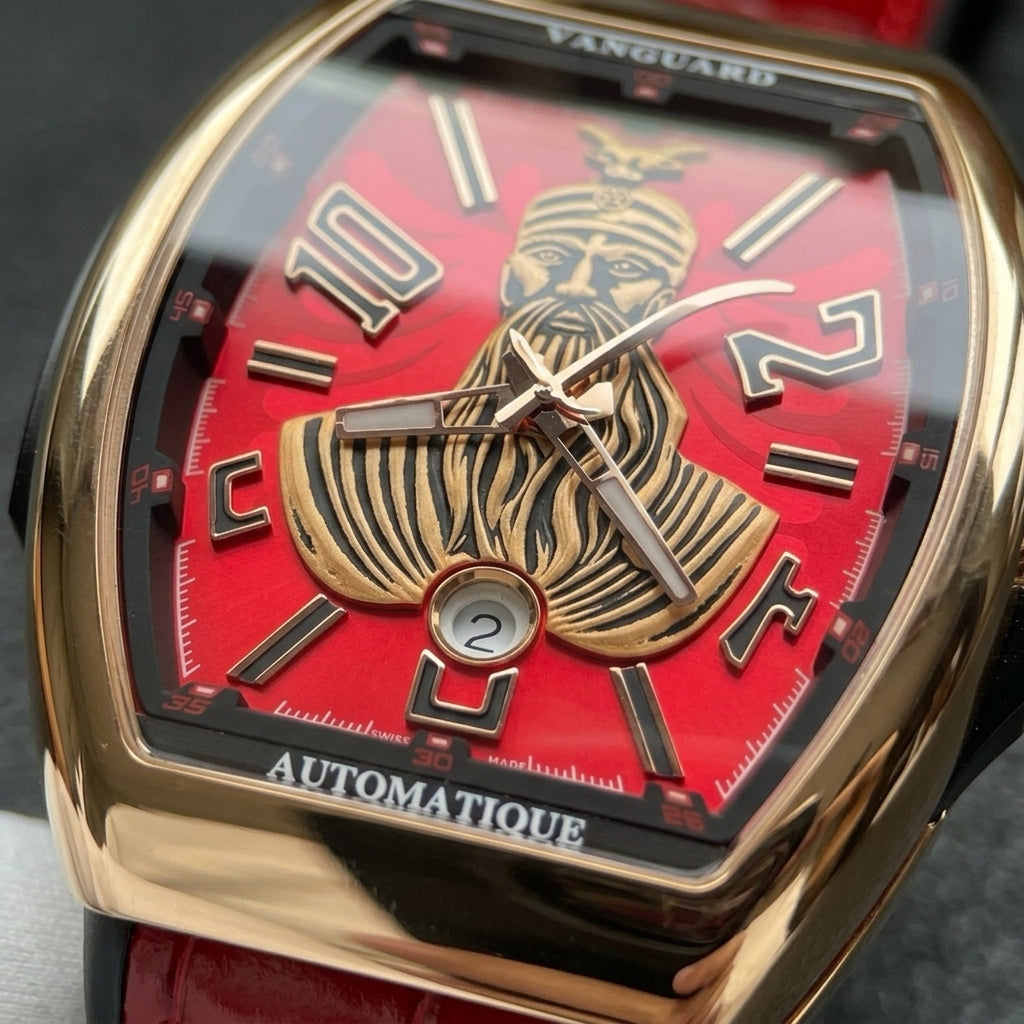 Macro of the red dial with the gold-tone bearded warrior in a goat-horned helmet, black numerals and the date window at six