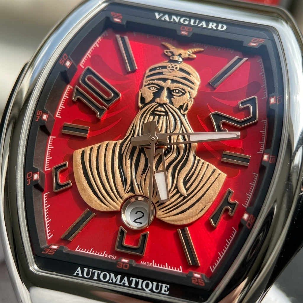 Macro of the red dial with the rose-gold-tone warrior bust in its goat-horned helmet, the black numerals and the date at six