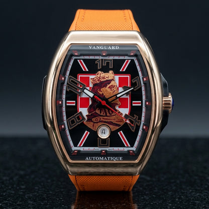 Rose gold curved tonneau watch with a black dial, a red-and-white checkerboard and a king's portrait, upright on dark slate
