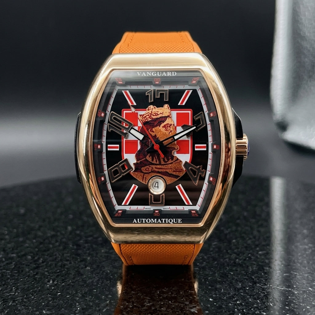 Rose gold curved tonneau watch with a checkerboard king dial on its orange strap, worn on the wrist below a dark suit cuff