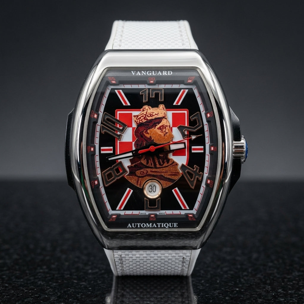 Steel curved tonneau watch on its white strap, worn on the wrist below a dark suit cuff