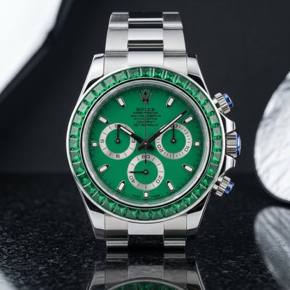 Green dial steel chronograph worn under a navy suit cuff