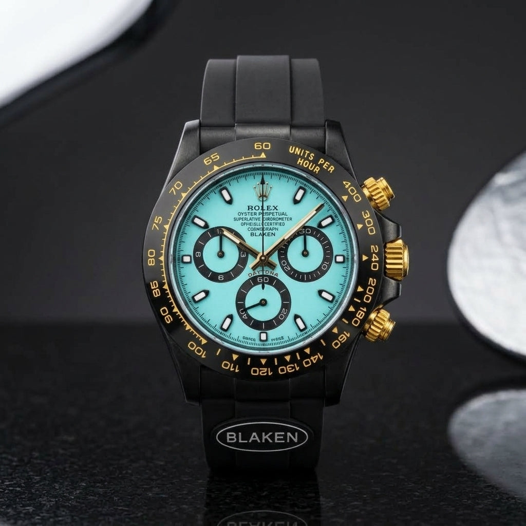 Black chronograph with an ice-blue dial worn under a navy suit cuff