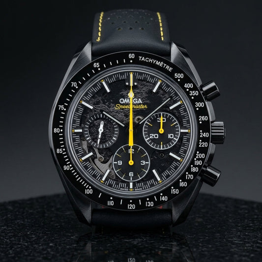 Black ceramic chronograph with a black moon relief dial and a yellow chronograph hand, standing upright on polished black granite