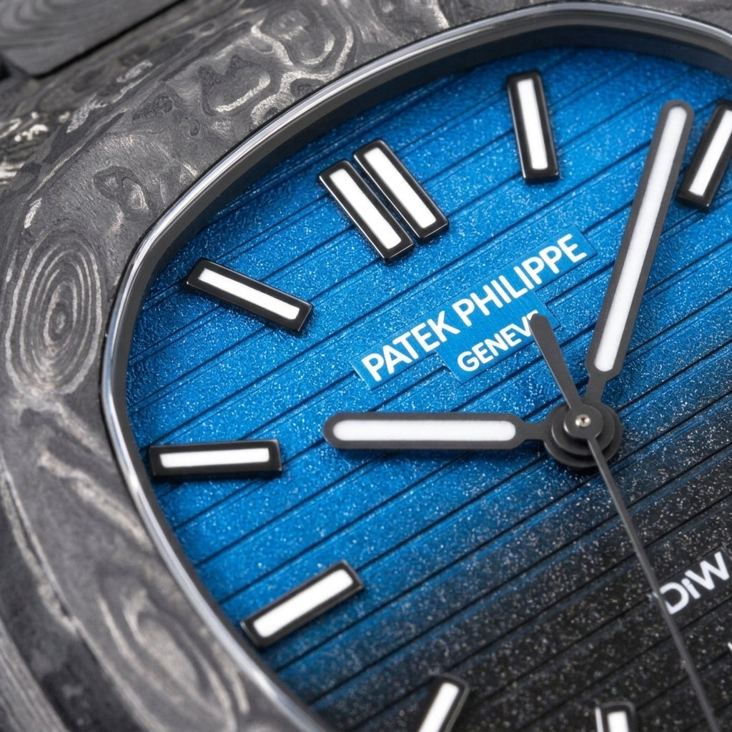 Macro of the frosted blue dial fading to glittering black across horizontal grooves, inside the forged carbon bezel