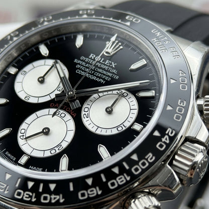 Macro of the black dial with three white counters ringed in black and steel baton markers with lume