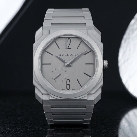 Ultra-thin sandblasted titanium octagonal watch upright on black granite