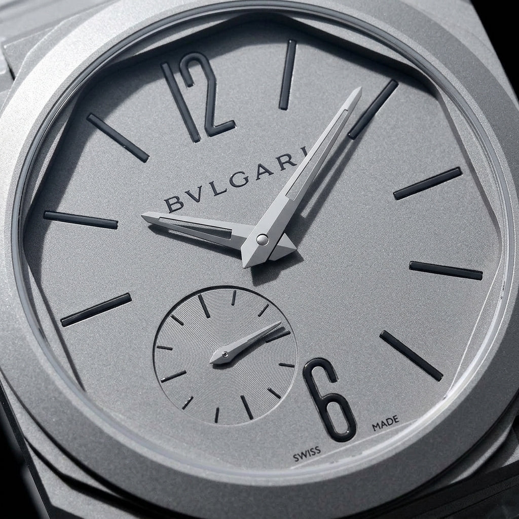 Macro of the grey sandblasted dial, small seconds and open 12 and 6