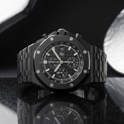 Black ceramic chronograph worn under a navy suit cuff