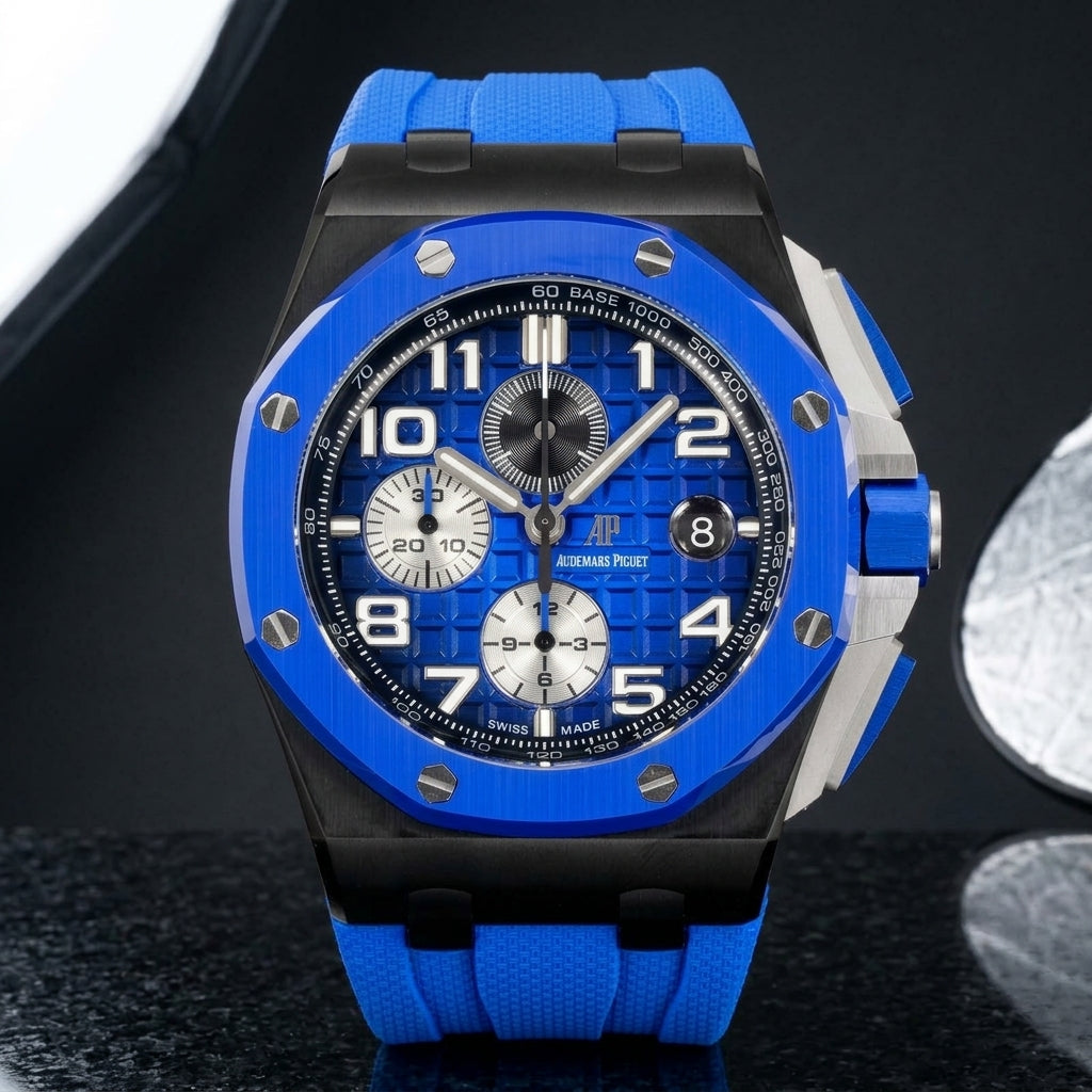 Blue ceramic chronograph on a blue rubber strap worn under a navy suit cuff