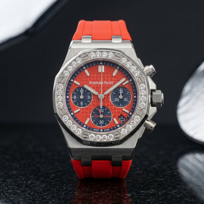 Red dial diamond bezel chronograph worn on the wrist