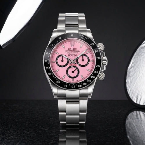 Pink-dial steel racing chronograph with a black ceramic bezel on black granite