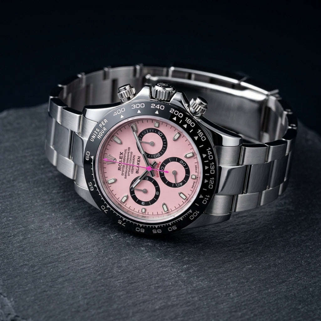 Pink-dial steel chronograph at a three-quarter angle on dark slate