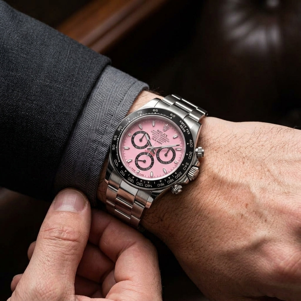 Pink-dial steel racing chronograph on the wrist as a shirt cuff is fastened