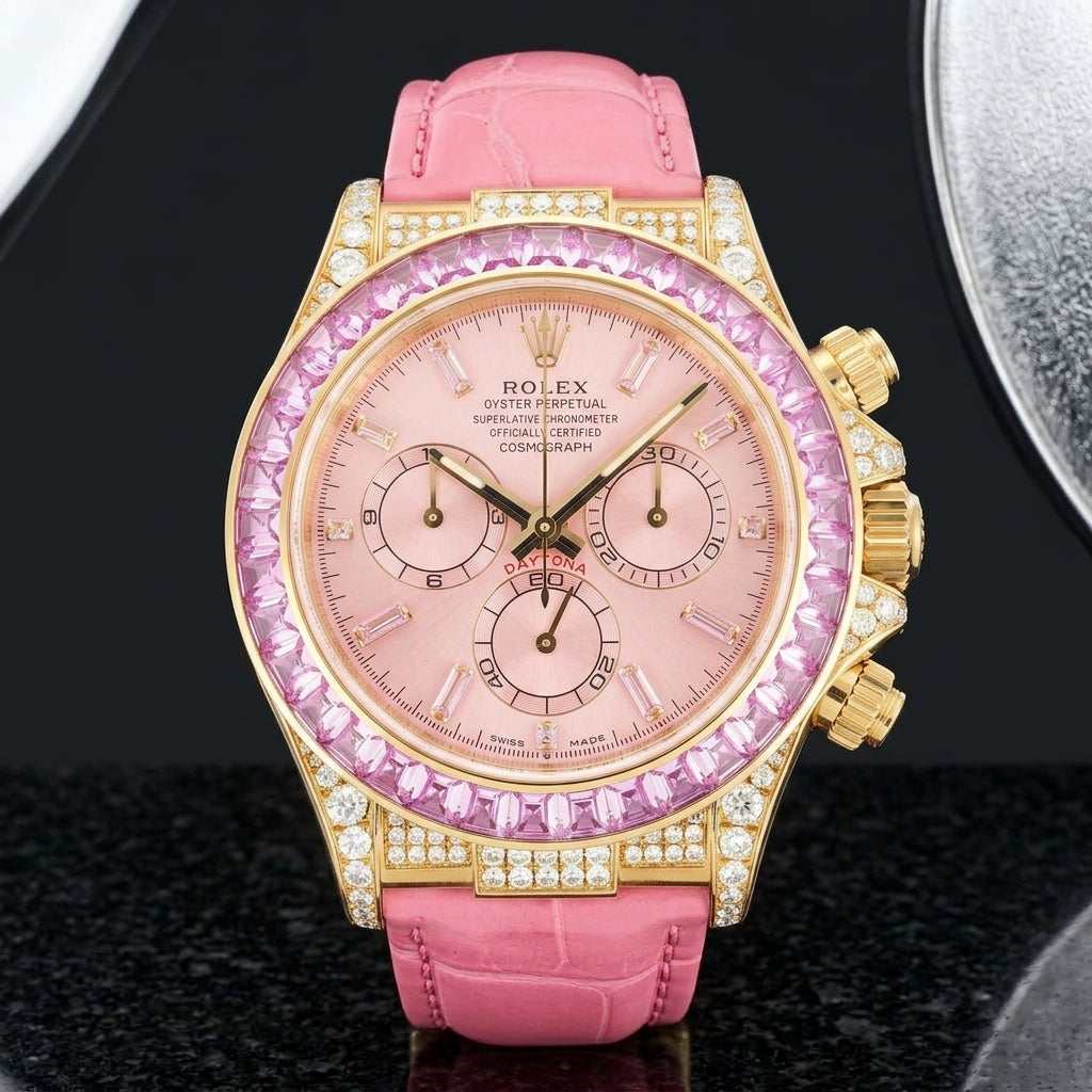 Yellow gold-wrapped chronograph with a pink dial, pink counters and a pink moissanite baguette bezel standing upright on polished black granite