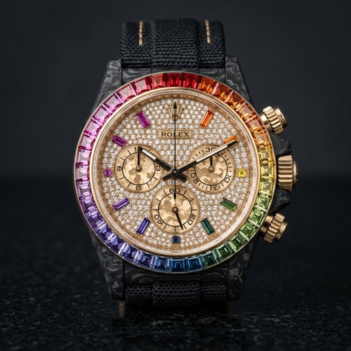 Black forged carbon chronograph with a rainbow gemstone bezel set in gold and a gold pavé dial, upright on polished black granite