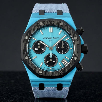 Octagonal chronograph with a sky-blue case, a black forged-carbon bezel and a sky-blue dial, upright on polished black granite