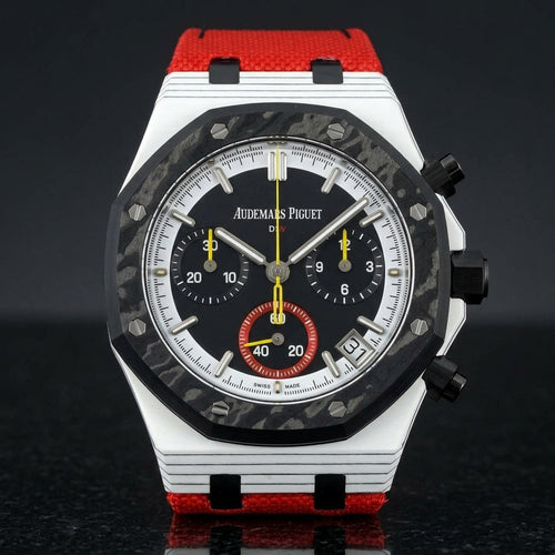 White octagonal chronograph with a black carbon bezel and a black dial, upright on polished black granite