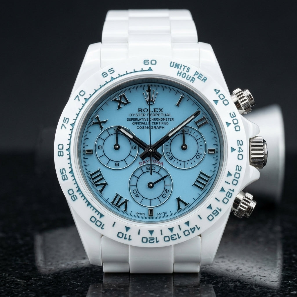 White ceramic chronograph with a light blue dial and steel Roman numerals, upright on polished white marble