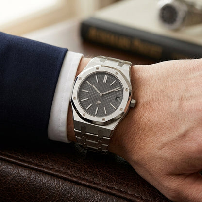 Extra-thin steel octagonal sports watch on its integrated bracelet, worn under a shirt cuff