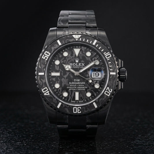 All-black forged carbon dive watch on black granite