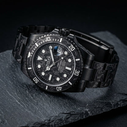 Forged carbon Submariner at a three-quarter angle on dark slate