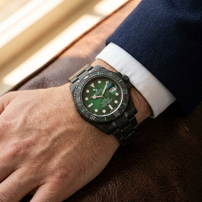 Green dial carbon dive watch worn under a navy suit cuff