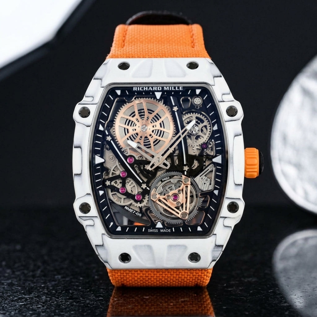 White carbon skeleton tourbillon watch on an orange woven strap, worn on the wrist below a navy suit cuff