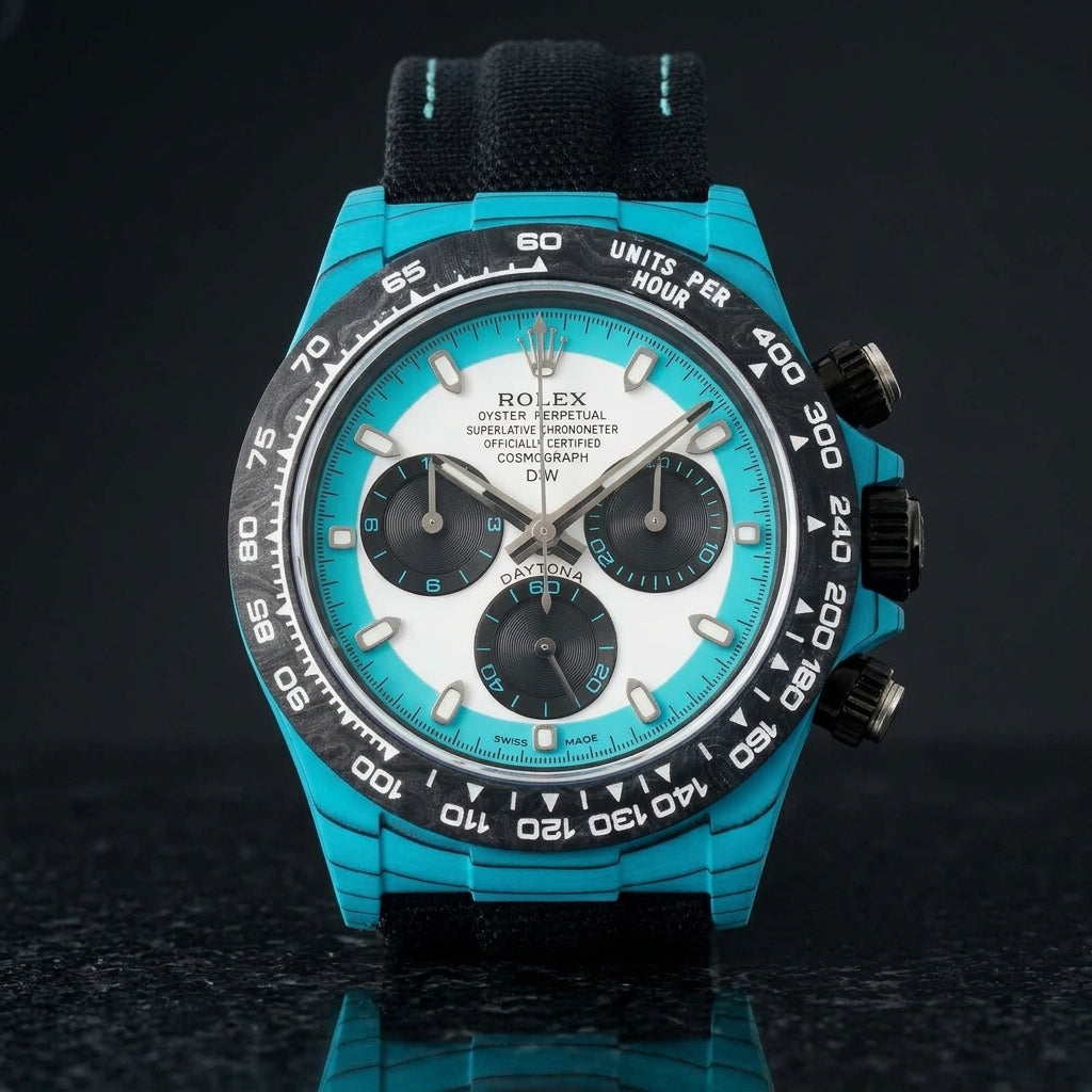 Turquoise-cased chronograph with a black carbon bezel and white dial on pale stone