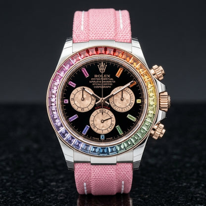White-cased chronograph with a rainbow stone bezel and a black dial, upright on polished black granite