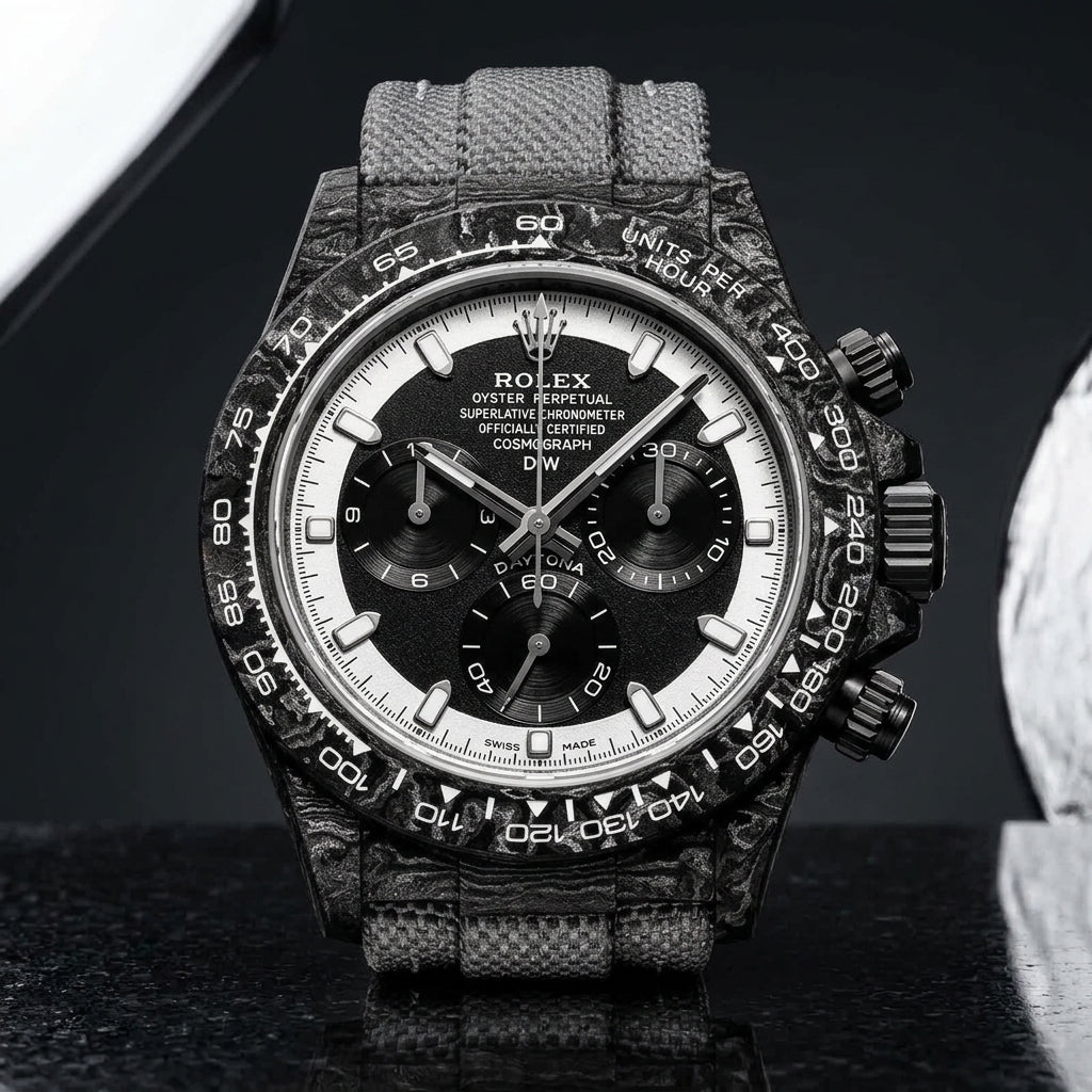Forged-carbon chronograph with a black dial inside a white chapter ring, on pale stone
