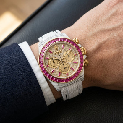 White carbon chronograph with a fuchsia stone bezel on its white woven strap, worn on the wrist below a cream sleeve